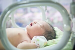 A premature baby sleeping in an incubator 
