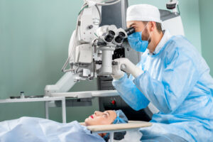 A surgeon using a medical device to look at a female patient's eyes.