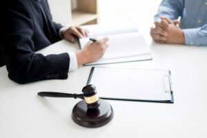 A personal injury solicitor sits at a desk with a client who is looking to make a bruised ribs injury claim on a No Win No Fee basis.