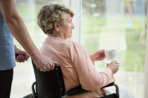 A woman sitting in a wheelchair in the care home she is a resident of