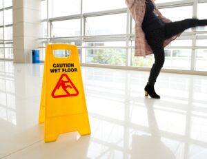 Office worker slipping on a wet floor in a foyer.