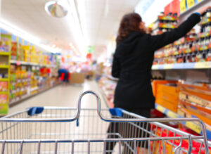 Woman at supermarket reaching for item.