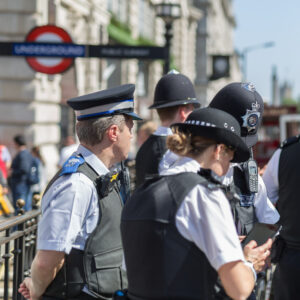 Several police officers stand together on a street in London.