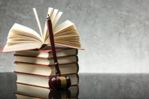 A gavel in front of a stack of legal text books 