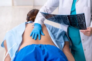 A person receiving a physical exam from a doctor after back injuries sustained at work